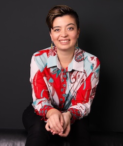 A photo of Emily, they are seated and smiling at the camera