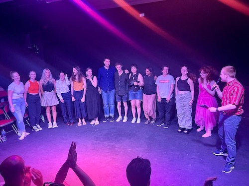 the cast and creatives of Early Dawn standing on stage at the curtain call